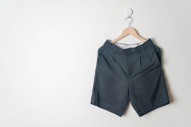 Kısa pantolon duvarda ahşap bir askıyla asılı.
