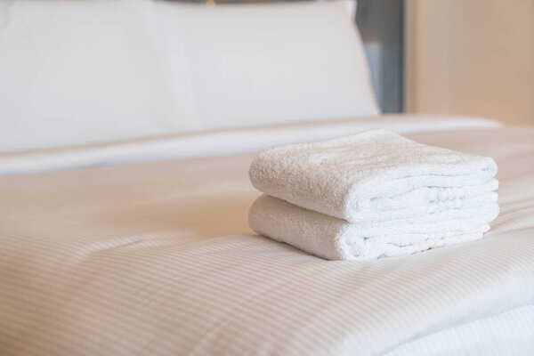white shower towel stack on bed