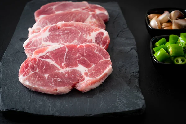 Taze domuz boyunlu ya da yakalı domuz eti ve terbiye edilecek malzemeler.