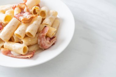 Beyaz soslu ve pastırmalı ev yapımı spagetti rigatoni makarna. İtalyan usulü.