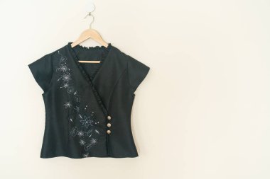 Duvarında ahşap askı asılı güzel bir kadın gömleği.