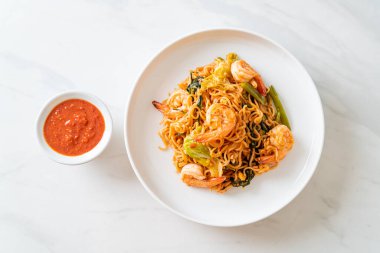 Karıştırılmış hazır erişteli sukiyaki, karidesli, Asya usulü.