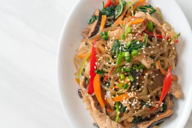 Japchae ya da karışık Kore vermicelli erişte sebzeli ve üzerine beyaz susamlı domuz eti - Kore geleneksel yemek tarzı