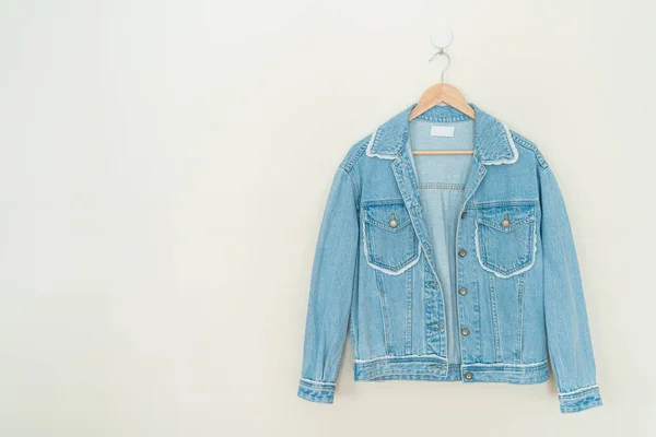 woman jacket jean hanging with wood hanger on wall