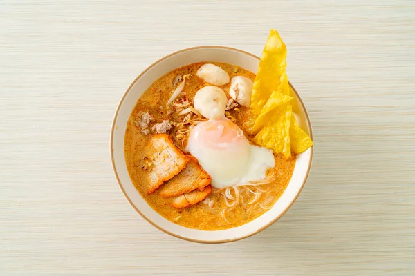 Rice vermicelli noodles with meatball, roasted pork and egg in spicy soup - Tom Yum Noodles
