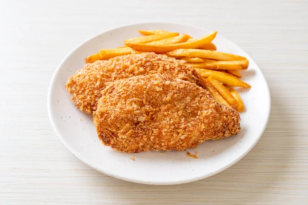 Kızarmış tavuk göğsü fileto biftek yanında patates kızartması ve ketçap.