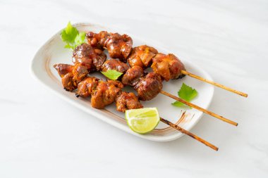 Izgara tavuk şişi. Tabakta baharat ve şifalı otlar var.