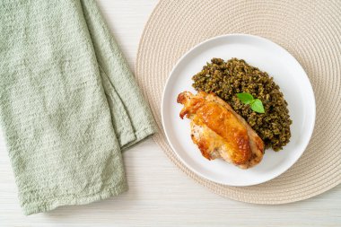 Kızarmış pesto pilavı ve beyaz tabakta kızarmış tavuk.