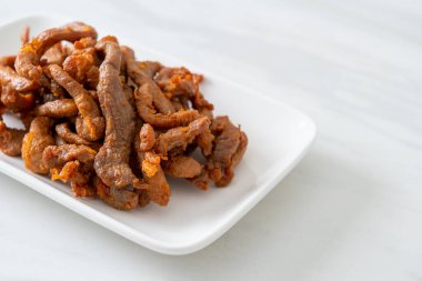 Beyaz tabakta kurutulmuş domuz eti, Asya yemeği tarzı.