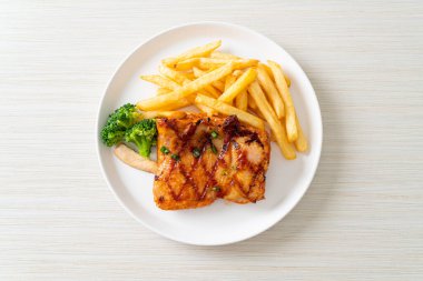 grilled chicken steak with potato chips or french fries on white plate