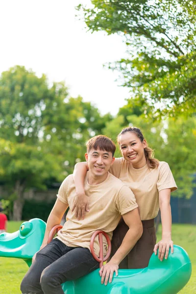Asian Couple Love Smiling Sitting Rockky Horse Playground — стоковое фото