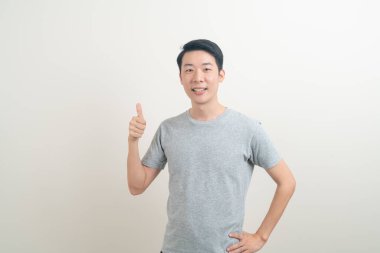 Beyaz arka planda eli işaret eden ya da sunan genç Asyalı adam portresi