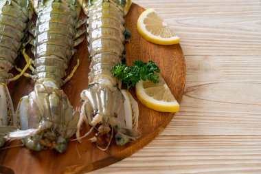 Tahtada limon olan taze peygamber devesi karidesi.