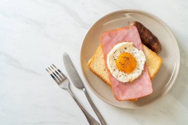 Ev yapımı kızarmış peynir üzerine jambon ve kahvaltıda domuz sosisli sahanda yumurta.