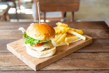 Tahta tepside peynirli biftek ve patates cipsi.