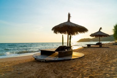 beach chair and umbrella with sea beach background at sunset time - Holidays and vacation concept