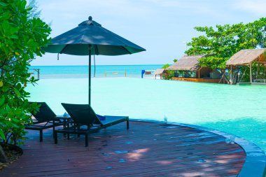 pool bed around swimming pool with sea background - Holidays and vacation concept