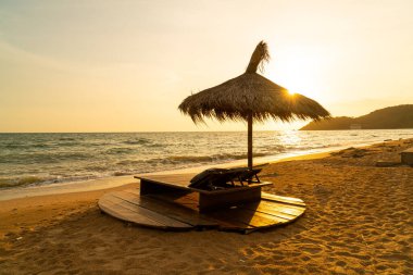beach chair and umbrella with sea beach background at sunset time - Holidays and vacation concept