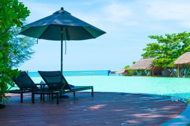pool bed around swimming pool with sea background - Holidays and vacation concept