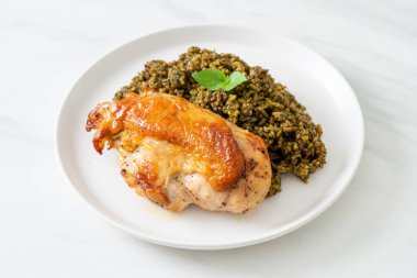 Kızarmış pesto pilavı ve beyaz tabakta kızarmış tavuk.