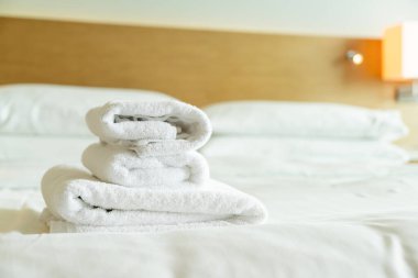 close-up white towel stack on bed