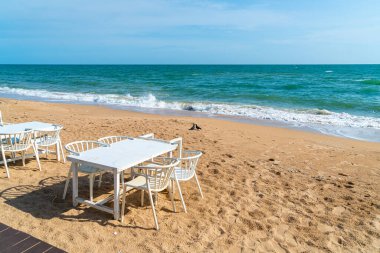 empty dinning table and chair on beach with sea background