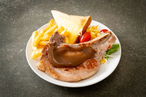 pork chop steak with chips and mini salad on white plate