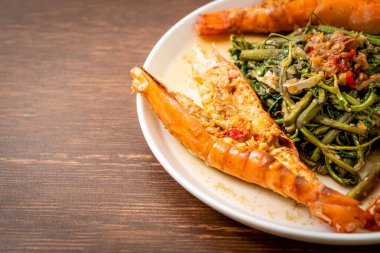 Tabağında nehir karidesleri olan kızarmış su mimozası.