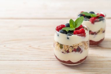 Ev yapımı ahududu ve yaban mersinli yoğurt ve granola. Sağlıklı yemek tarzı.