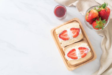 gözlemeli sandviç, çilekli taze krema, ahşap tabakta.