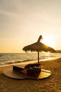 beach chair and umbrella with sea beach background at sunset time - Holidays and vacation concept