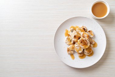 Izgarada dilimlenmiş muz ve karamel sosu.