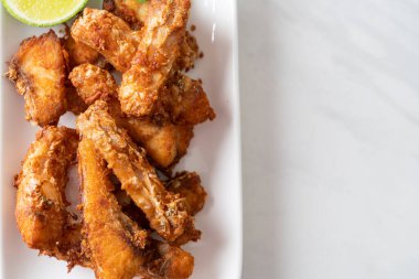 Fried Snapper Belly on white plate - Asian food style