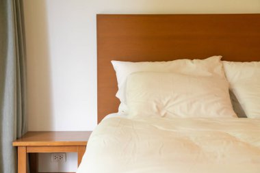 Yatak odasındaki beyaz yastık süslemesi