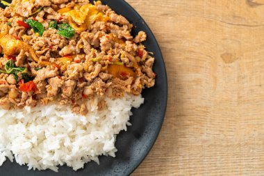 Pirinçli yumurta ve fesleğenli kızarmış domuz eti. Asya usulü.