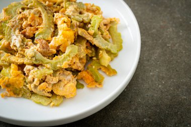 Kızarmış acı kabağı tabakta yumurta ile karıştır