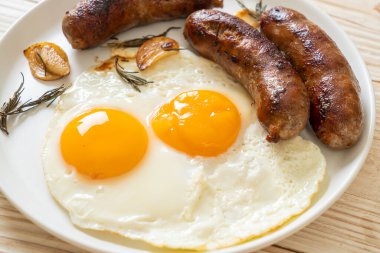 Kahvaltıda omlet ve kızarmış domuz sosisi.