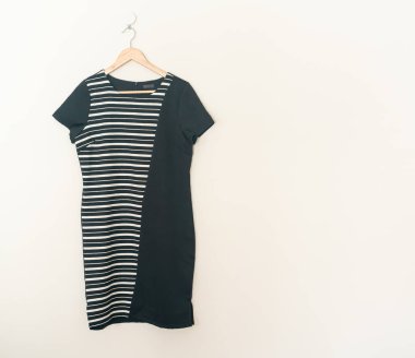 beautiful black dress hanging with wood hanger on wall