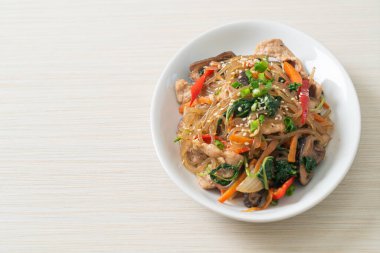 Japchae ya da karışık Kore vermicelli erişte sebzeli ve üzerine beyaz susamlı domuz eti - Kore geleneksel yemek tarzı