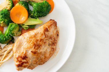 Beyaz tabakta sebzeli ızgara tavuk bifteği