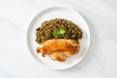 Kızarmış pesto pilavı ve beyaz tabakta kızarmış tavuk.