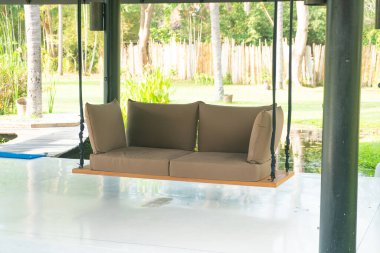 Boş kanepe dinlenmek için bahçede sallanıyor.