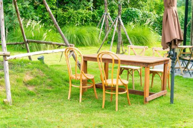 Boş ahşap masa ve bahçede sandalye.