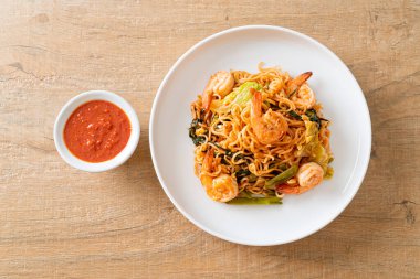 Karıştırılmış hazır erişteli sukiyaki, karidesli, Asya usulü.