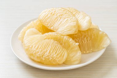 Taze soyulmuş zeytin, greyfurt ya da beyaz tabakta Shaddock.