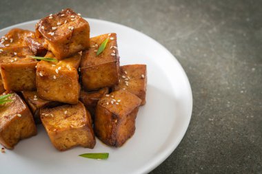 Beyaz susamlı kızarmış tofu ve teriyaki sosu. Vejetaryen ve vejetaryen yemek tarzı.