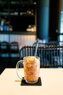 Kahve dükkanında ve restoranda bardakta buzlu Tayland çayı.