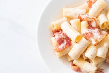 Beyaz soslu ve pastırmalı ev yapımı spagetti rigatoni makarna. İtalyan usulü.