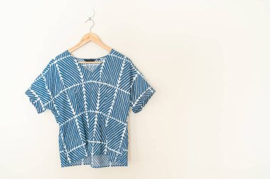 tie dye shirt hanging with wood hanger on wall