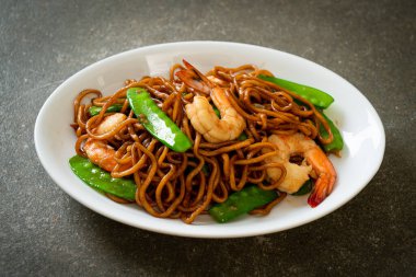 Kızarmış yakisoba eriştesi, yeşil bezelye ve karides, Asya usulü.